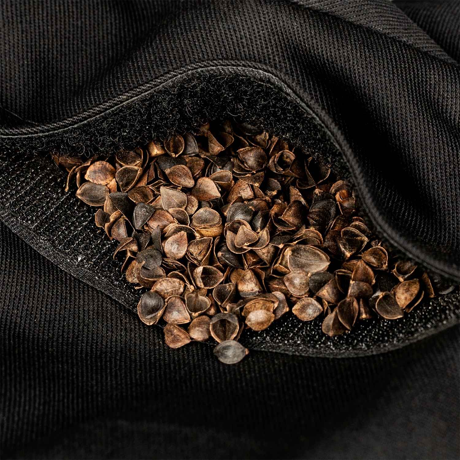 Zbliżenie na detal klinu dla osób z bólem kości ogonowej - zbliżenie na rzep do regulacji wypełnienia i naturalną łuskę gryki,